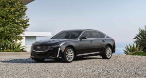 A black 2022 Cadillac CT5 parked near a modern home.